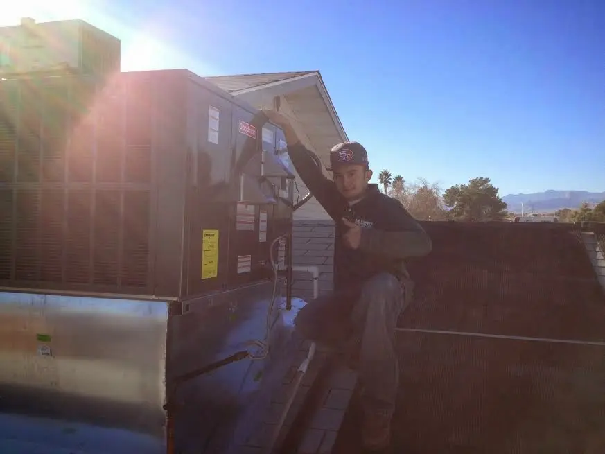 HVAC technician performing HVAC Inspection on a rooftop unit in Marion